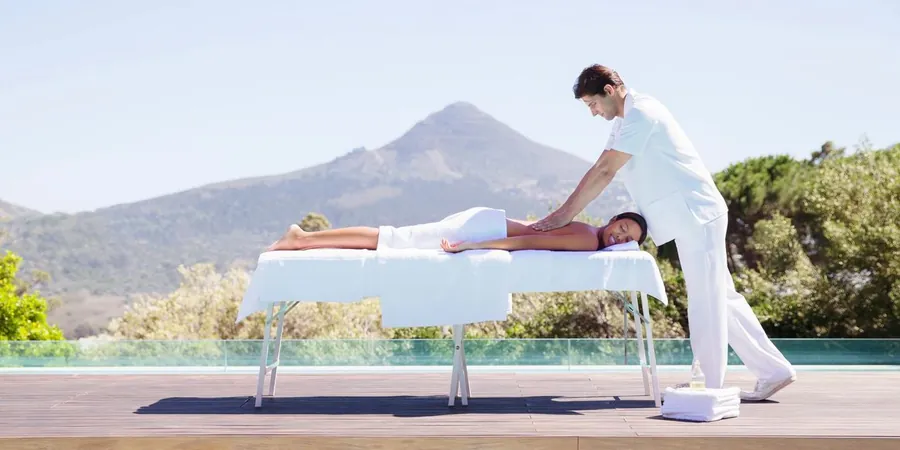 A massage therapist treating a relaxed client